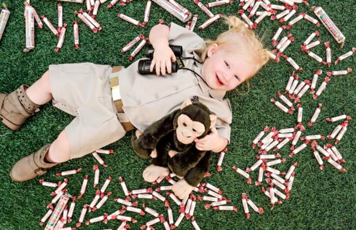ein süßes kleines Mädchen mit Gorilla Spielzeug, mit Fernglas, Halloween Verkleidung wie kleine Forscherin