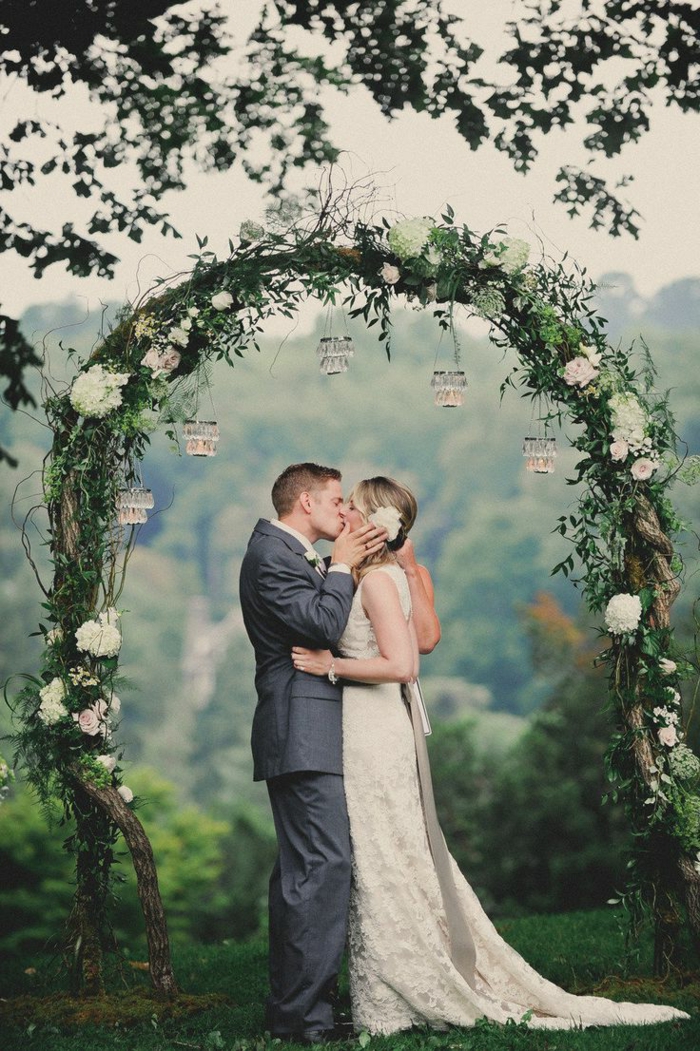 eine schöne Hochzeit von verliebten Brautpaar, ein Bogen aus weißen Blumen, DIY Windlichter, Hochzeitsfeier Ideen