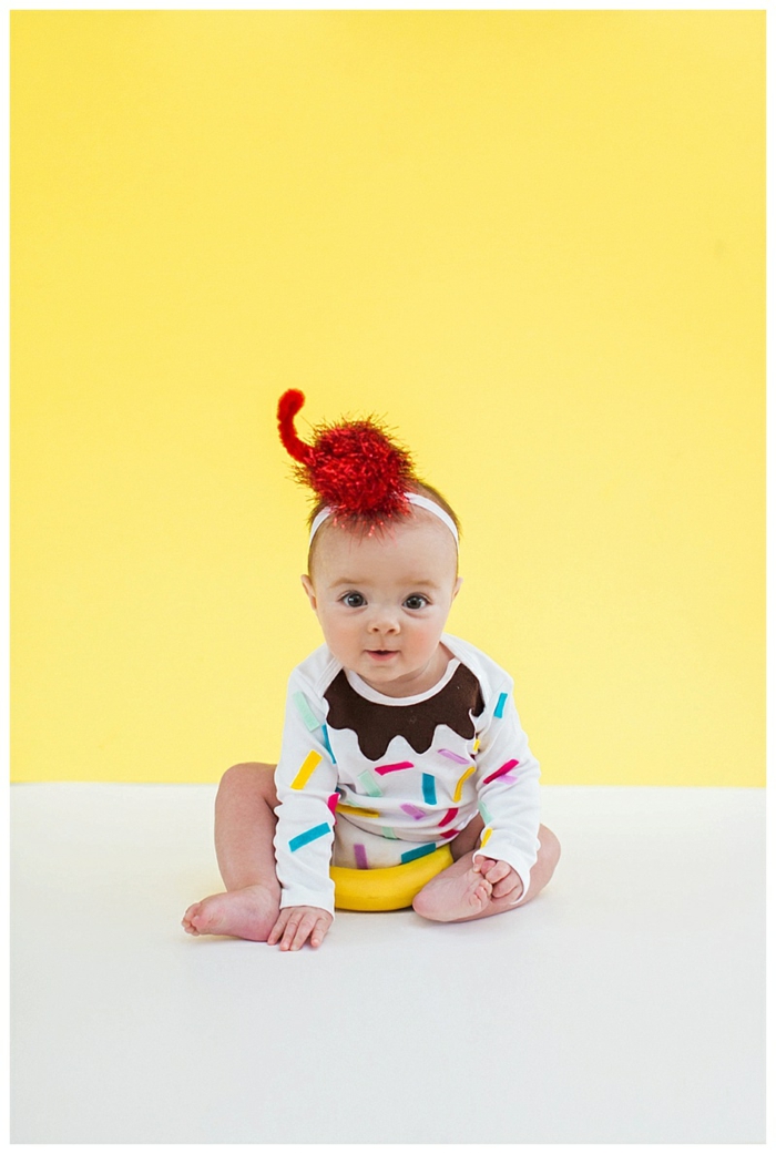 ein niedliches Baby mit weißem Babybody voller Konfetti, ein Haarband, Halloween Kostüm für Kind selber machen