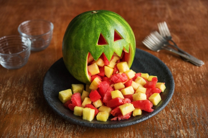 eine Wassermelone, die Melone und Ananasstücke kotzt, Halloween Rezepte für gruselige Stimmung
