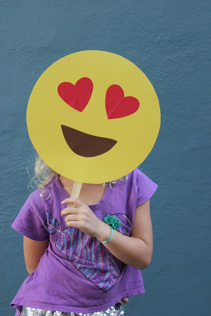 ein Gesicht von den Emojis, die verliebte Miene, ein Mädchen mit lila Bluse, schnelles Halloween Kostüm
