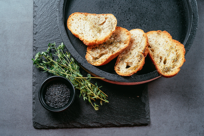 Kleine Brotscheiben mit Olivenöl beträufeln, mit Salz und Thymian würzen