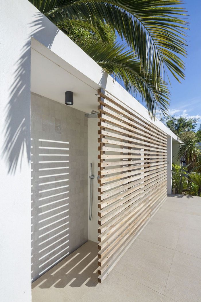 haus mit einer weißen terrasse mit grünen palmen und einer outdoor dusche mit sichtschutz aus holz, gartengestaltung ideen diy