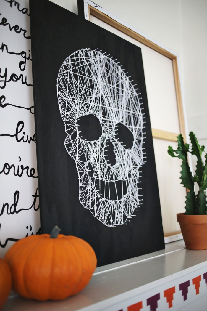 halloween deko basteln, großes bild mit schädel aus weißem faden, kürbisse