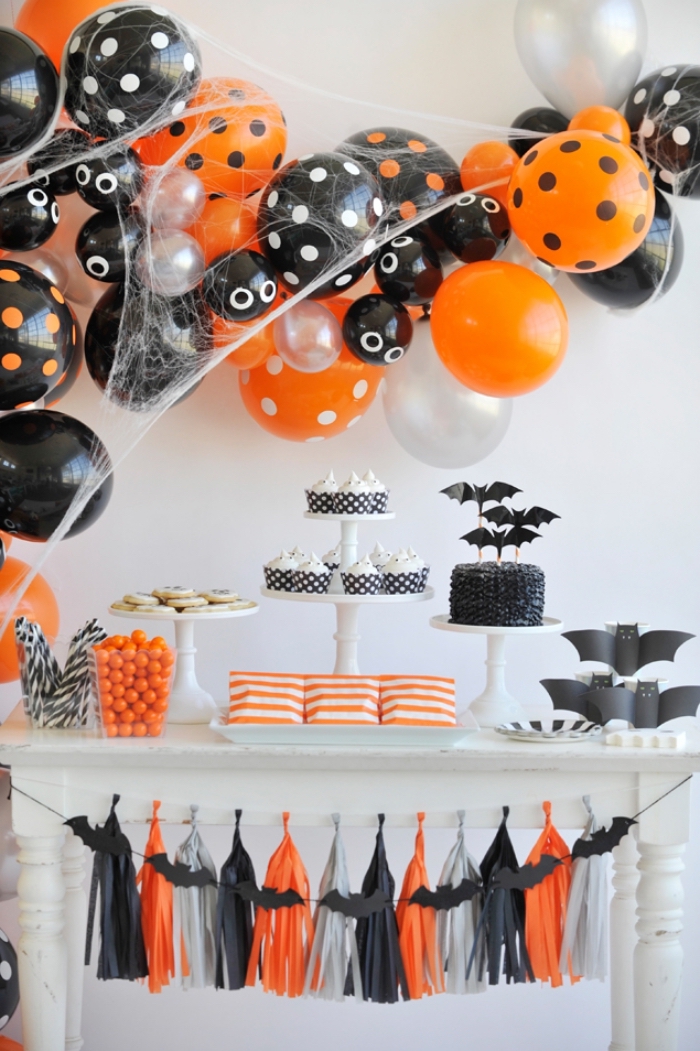 halloween deko ideen, party deko selber machen, shwarze und orangenfarbene ballons, girlande mit großen troddeln