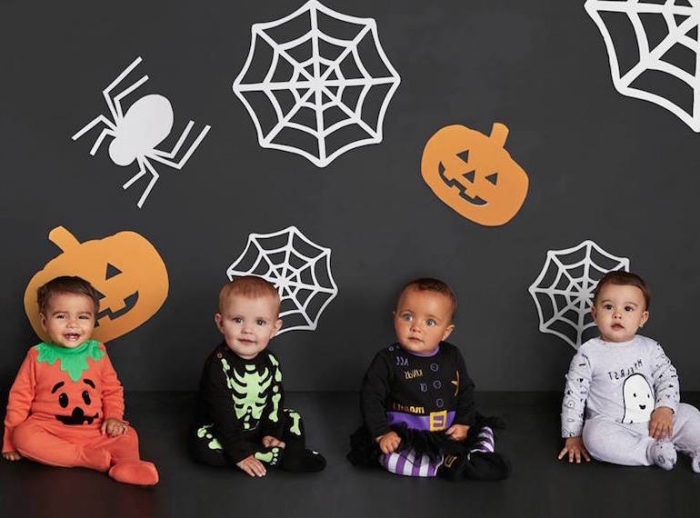 halloween kostüme für kidner, schwarze wand dekoriert mit spinnen, spinennetzen und kürbissen, babys