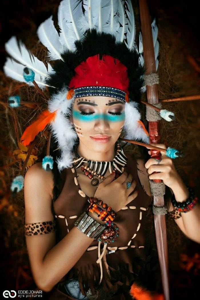 indianer schminke, frau mit großem kopfschmuck mit federn, blauer lidschatten, viele armreifen
