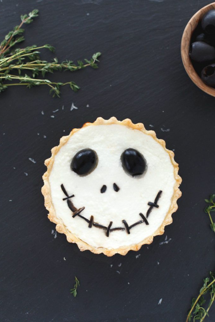 ein Kopf von Strohpuppe aus Cupcake, kleine Augen aus Bonbons und Schokolade Mund. Halloween Menü