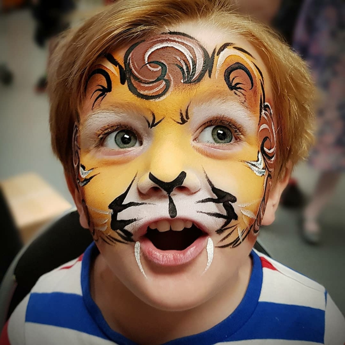 ein Tiger auf das Gesicht des Kindes bemalt, Halloween Schminktipps, scharfe Zähne