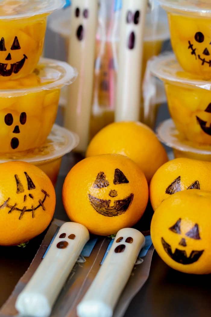 Mandarinen wie Kürbisgesichter, gesundes Halloween Menü, Kerzen in weißer Farbe auch mit Gesichter wie Gespenster