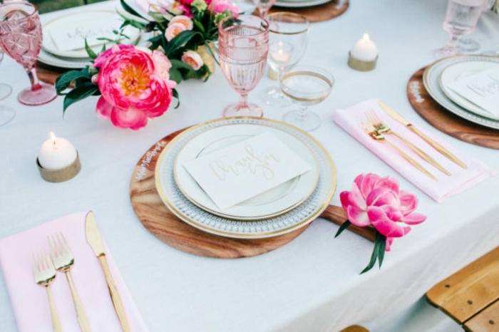Untersilie aus Holz mit rosa Blume als Hochzeitsdekoration, rosa Serviette und goldfarbenes Besteck