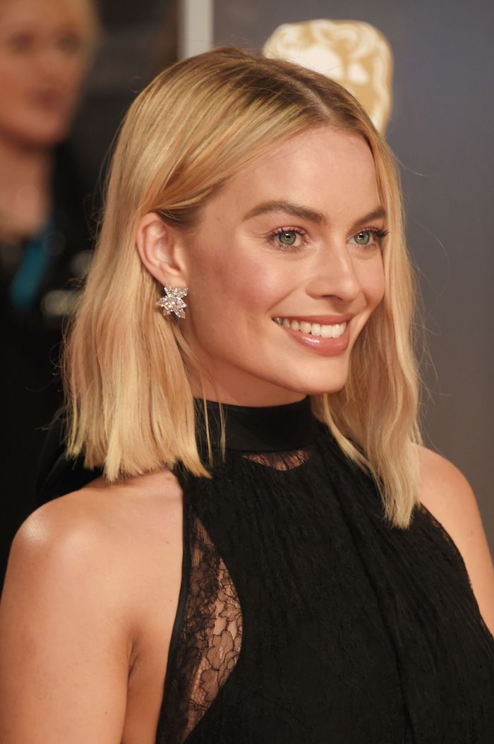 Lob mit Mittelscheitel, glatte blonde Haare, schwarzes Outfit und silberne Ohrringe mit Kristallen
