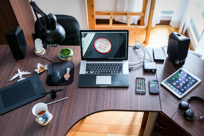 ein Schreibtisch aus Holz, mit Laptop darüber