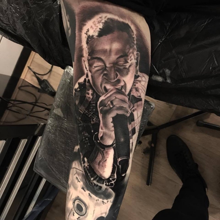 tattoo bilder arm, realitische tätowierung am oberarm, chester, mann mit mikrofon