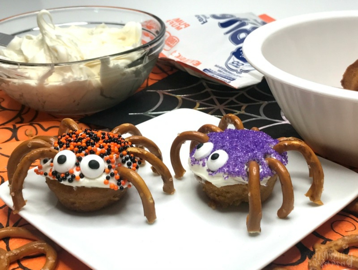 Spinnen aus Donuts mit Brezelstangen als Beine, weiße Creme und bunte Streuseln, Halloween Snack Ideen