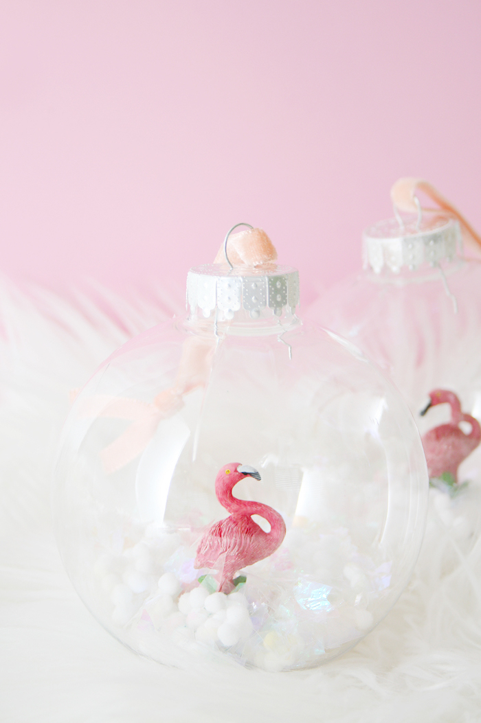 Kleine Flamingo Figuren in durchsichtige Christbaumkugeln stecken, Weihnachtsschmuck selber machen