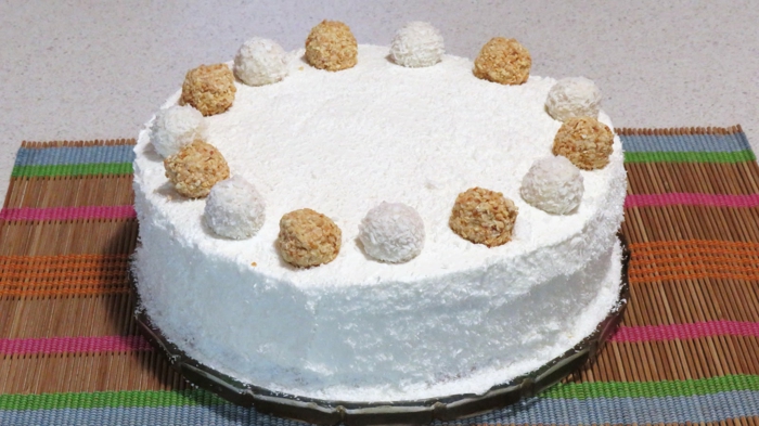 Raffaello Torte mit schneeweißer Creme und zwei Arten von Pralinen als Deko, Torte selber machen