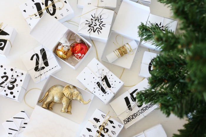 Adventskalender befüllen mit kleinen Spielzeugen, Zettelchen und Süßigkeiten, weiße Schachtel mit schwarzen Nummern