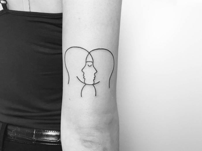 tattoo unterarm frau, eine kunstvolle abzeichnung, bei der zwei gesichter zu einem werden