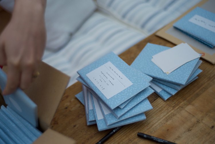 viele kleine blaue Briefumschläge mit den Adressen der eingeladenen zur Hochzeit, Einladungskarten selber basteln