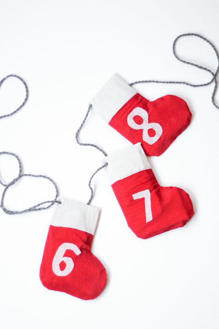 rote Stiefel mit Nummern in weißer Farbe, von einem Schnur gehängt, Weihnachtskalender basteln