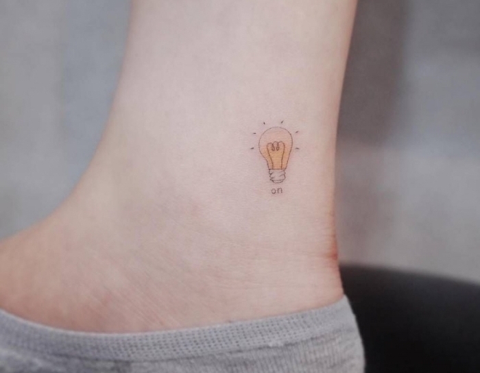 kleine tattoos am knöchel, fußtattoo, gelbe glühbirne, die an ist, das licht einschalten