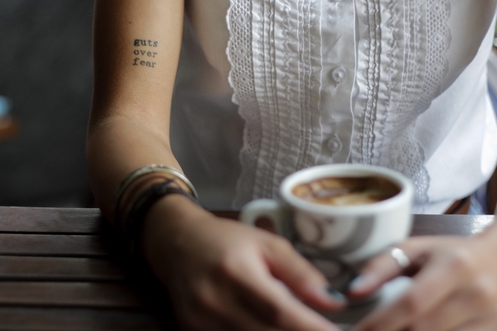 tattoo bilder, kaffee in den händen halten, armbänder, aufschrift in schwarz am hand