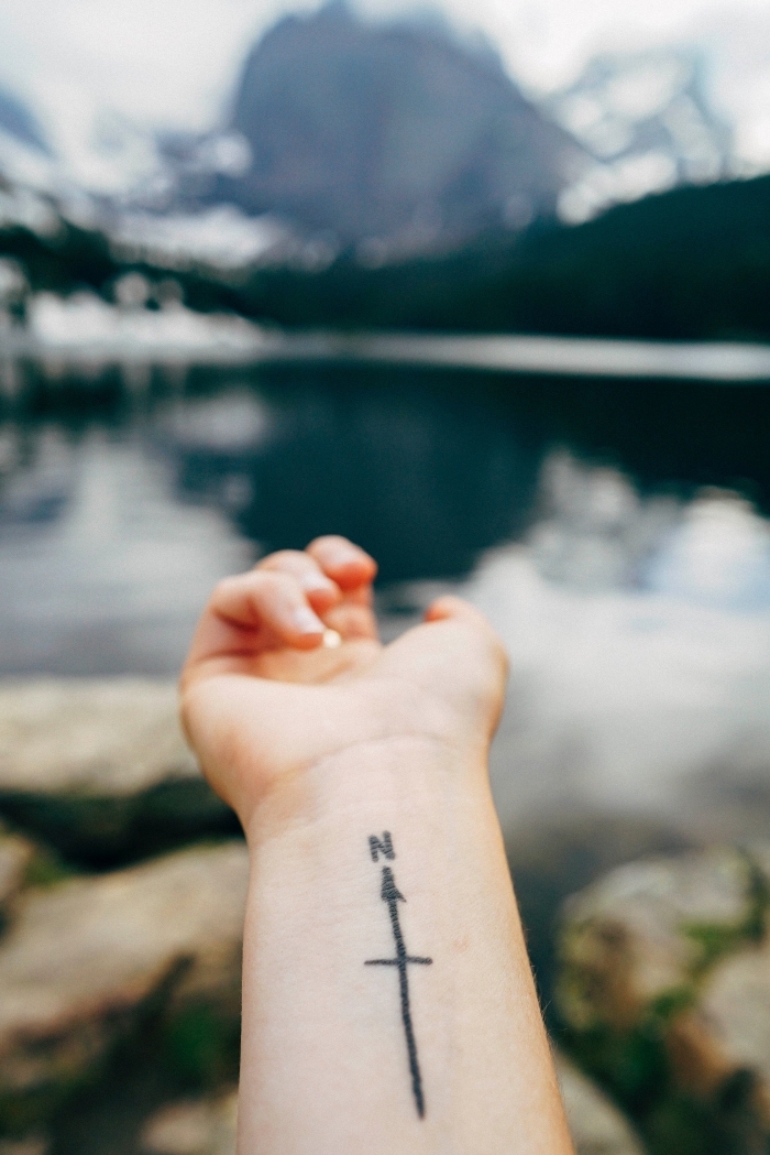 tattoos mit bedeutung, kompass tattoo, das in richtung des herzens zeigt, gebirge im hintergrund
