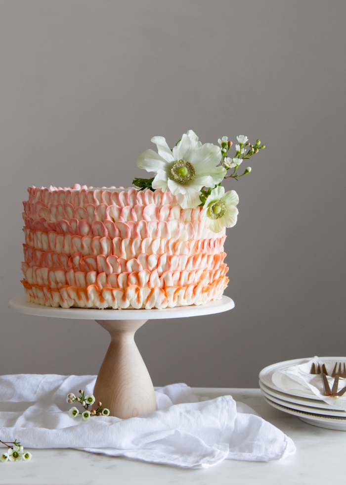 torte dekorieren mit buttercreme in weiß und orange, rüschentorte selber machen, weiße blüten