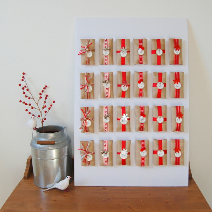 DIY Adventskalender aus einen Menge Klopapierrollen mit roten Schleifen und runde Anhänger