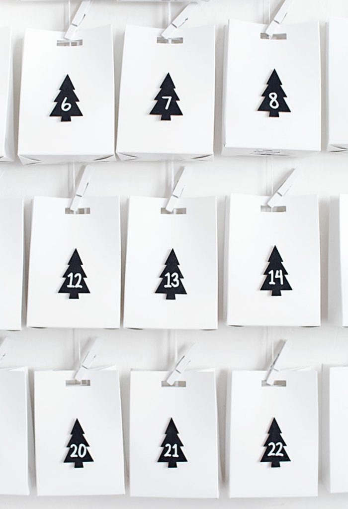 weiße Tüten mit schwarzen Tannenbäumenfiguren mit Nummern, Adventskalender basteln