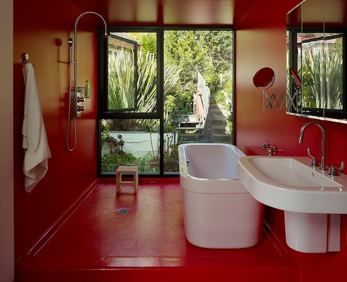 roter boden und eine weiße badewanne und weißes waschbecken, badezimmer modern, badezimmer mit fenster