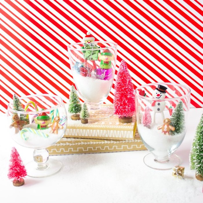 Kreative Idee für selbstgemachte Weihnachtsdeko, Gläser voll mit künstlichem Schnee und kleinen Weihnachtsfiguren 