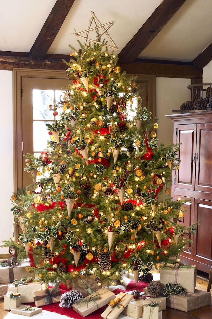 Riesiger echter Weihnachtsbaum mit viel schmuck, viele Weihnachtsgeschenke unter dem Baum 