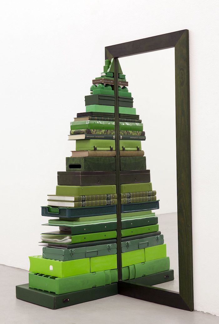 Coole Alternative zum klassischen Weihnachtsbaum, Christbaum aus grünen Koffern und Büchern neben Spiegel 