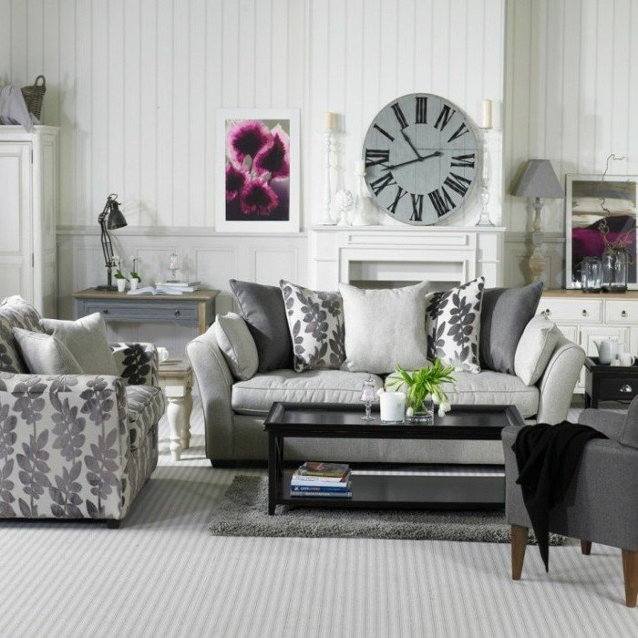 Wohnzimmer in Grau und Weiß, eine Wanduhr, ein graues Sofa und grauer Teppich, weiße Wandfarbe