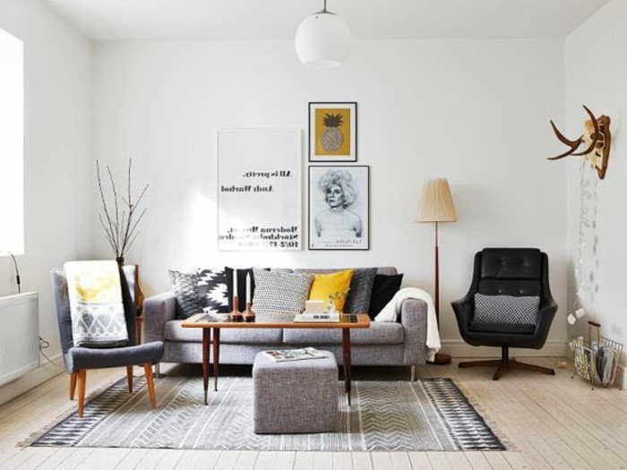 ein graues Sofa, gemusterter Teppich, zwei Sessel, drei Bilder, viele Bilder, Wohnzimmer in Grau Weiß