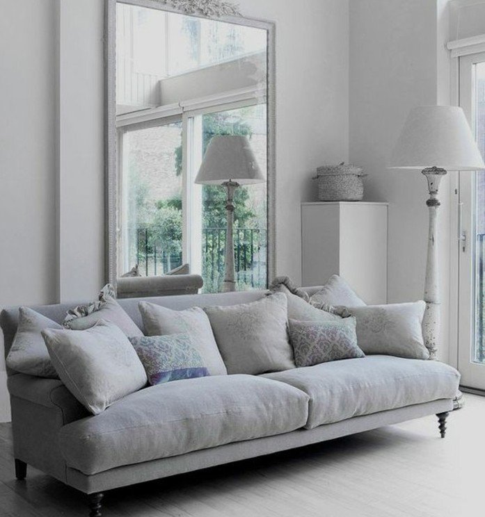 ein großer Spiegel und ein graues Sofa, ein weißer Teppich, Wohnzimmer streichen Grau Weiß
