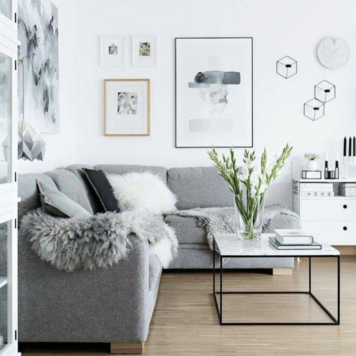 Wohnzimmer streichen Grau Weiß, ein graues Sofa, ein weißer Tisch, Laminat Boden, moderne Bilder an den Wänden