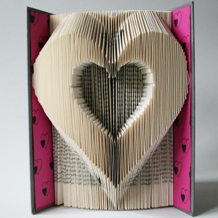 Zwei Herzenfiguren, eine kleine und eine große, rosa Buchumschlag mit Herzen versehen, Origami Buch