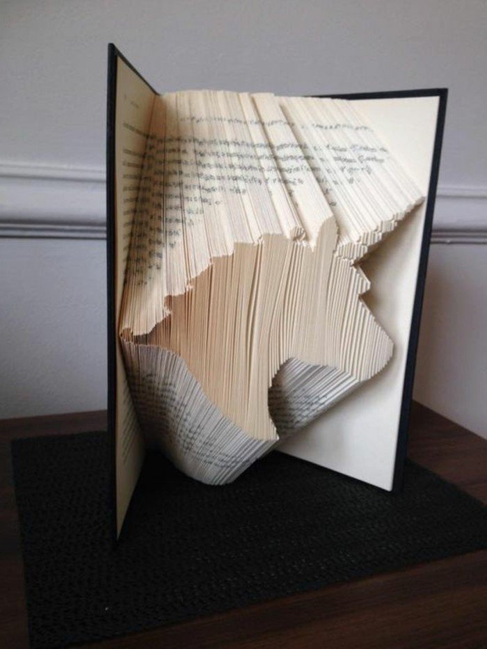 eine Einhornfigur aus Papier, Origami Buch, schwarzer Buchumschlag, ein fantastisches Bild