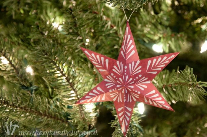 ein roter Stern mit Motiven von Schneeflocke, Weihnachtsstern falten und damit Weihnachtsbaum schmücken