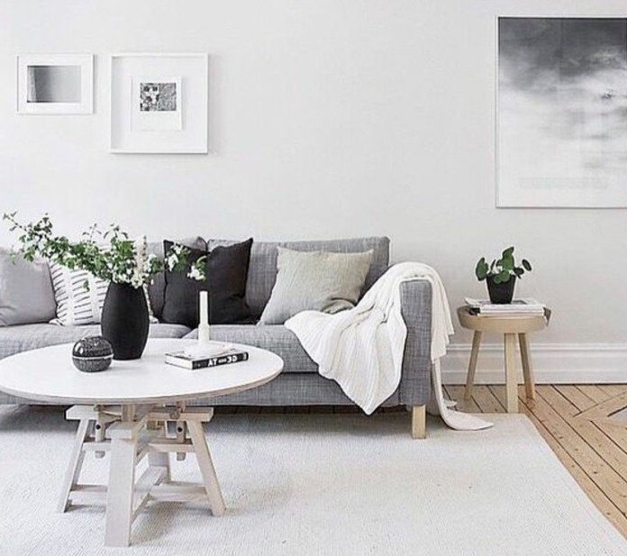 ein graues Sofa, Wohnzimmer streichen Grau Weiß, weißer Teppich, schwarze Vase mit weißen Blumen