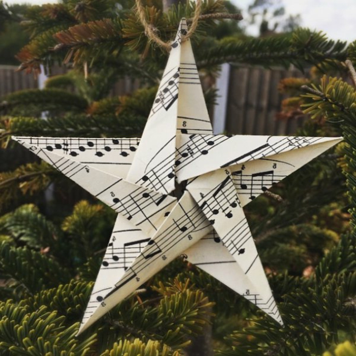 ein Stern aus Altpapier mit Noten versehen, von einem Seil gehängt, Weihnachtssterne falten