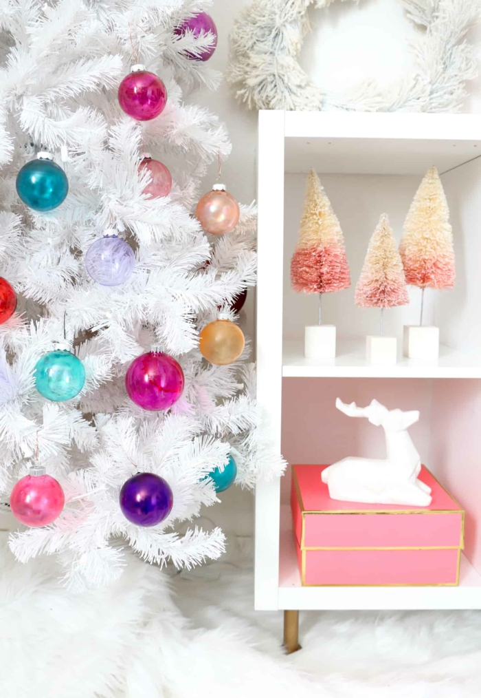eine Dekoration im Wohnzimmer, weißer künstlicher Weihnachtsbaum mit bunten Christbaumkugeln selber gestalten