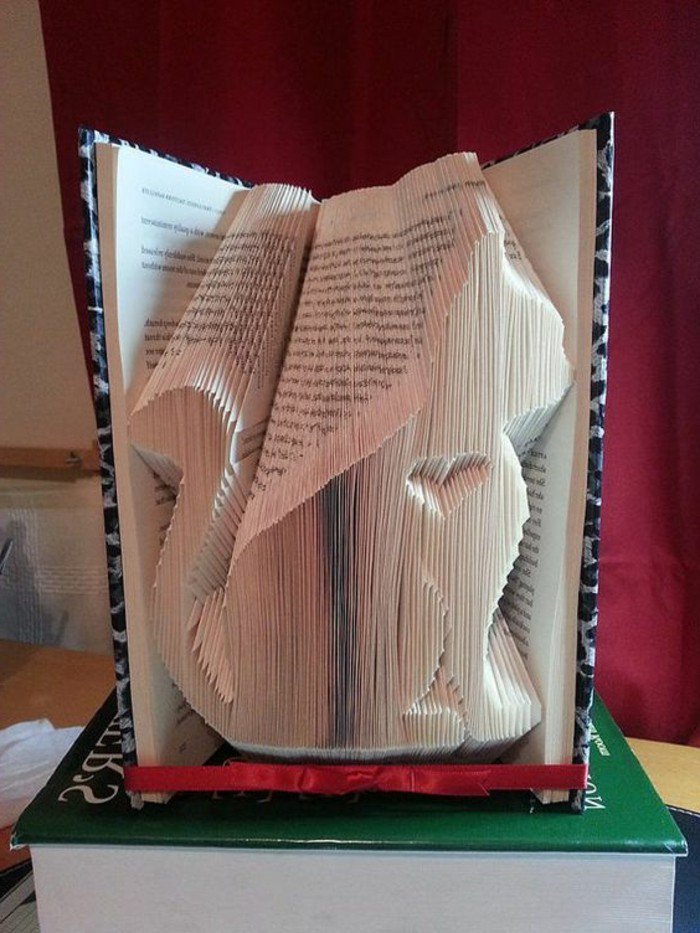 eine Katze aus Papier mit einem kleinen Herz in dem Buch geschnitzt, Buchfalttechnik