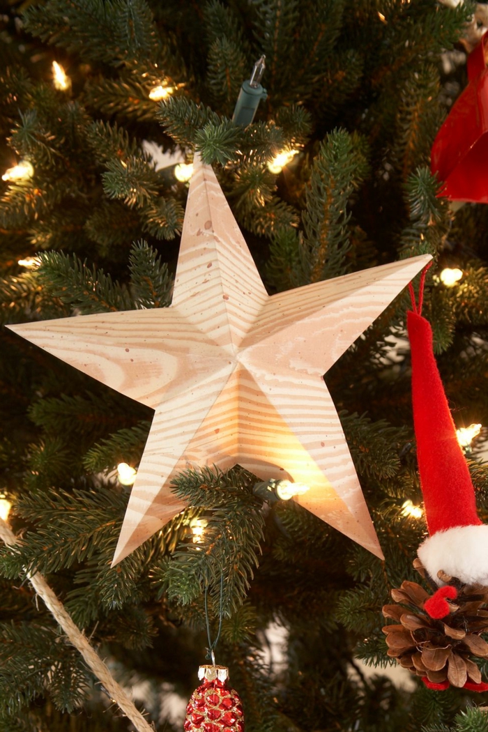 ein Stern aus Holz an dem Tannenbaum, eine Lichterkette, kleine Dekorationen, Bastelideen Weihnachten
