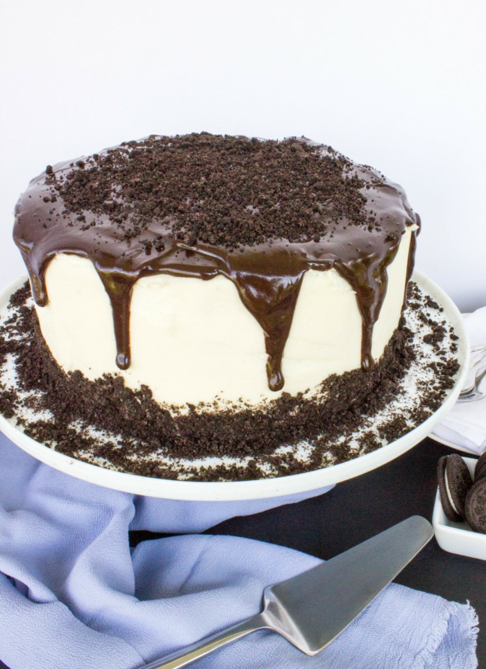 weiße Creme, Schokoladentopping, Oreo Kuchen mit Oreo Streuseln, mit blauem Tuch umgeben