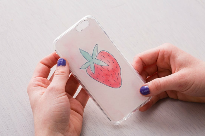Handyhülle personalisieren, Bild von einer Erdbeere, Hand mit lila Nagellack, Hand hält Hülle 