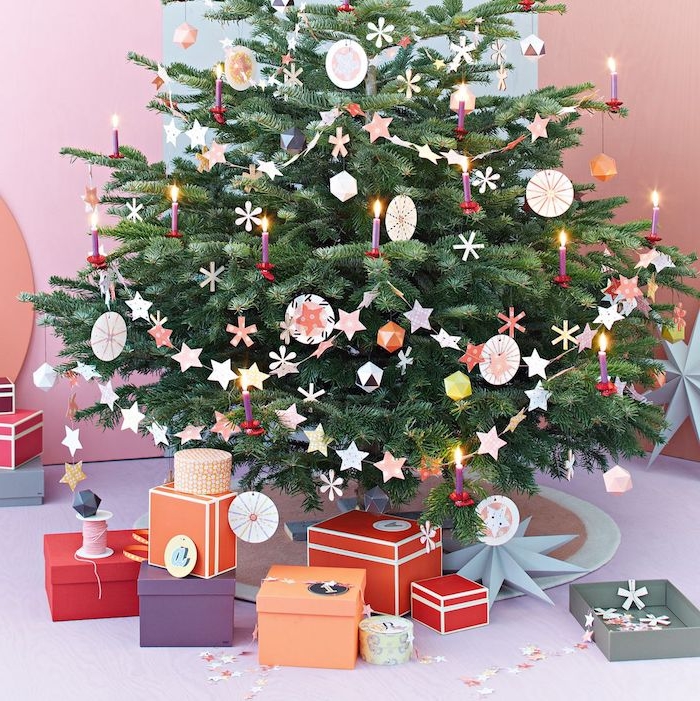 Echter Weihnachtsbaum geschmückt mit Anhängern und Girlanden aus Papier, Geschenkschachteln unter dem Baum 